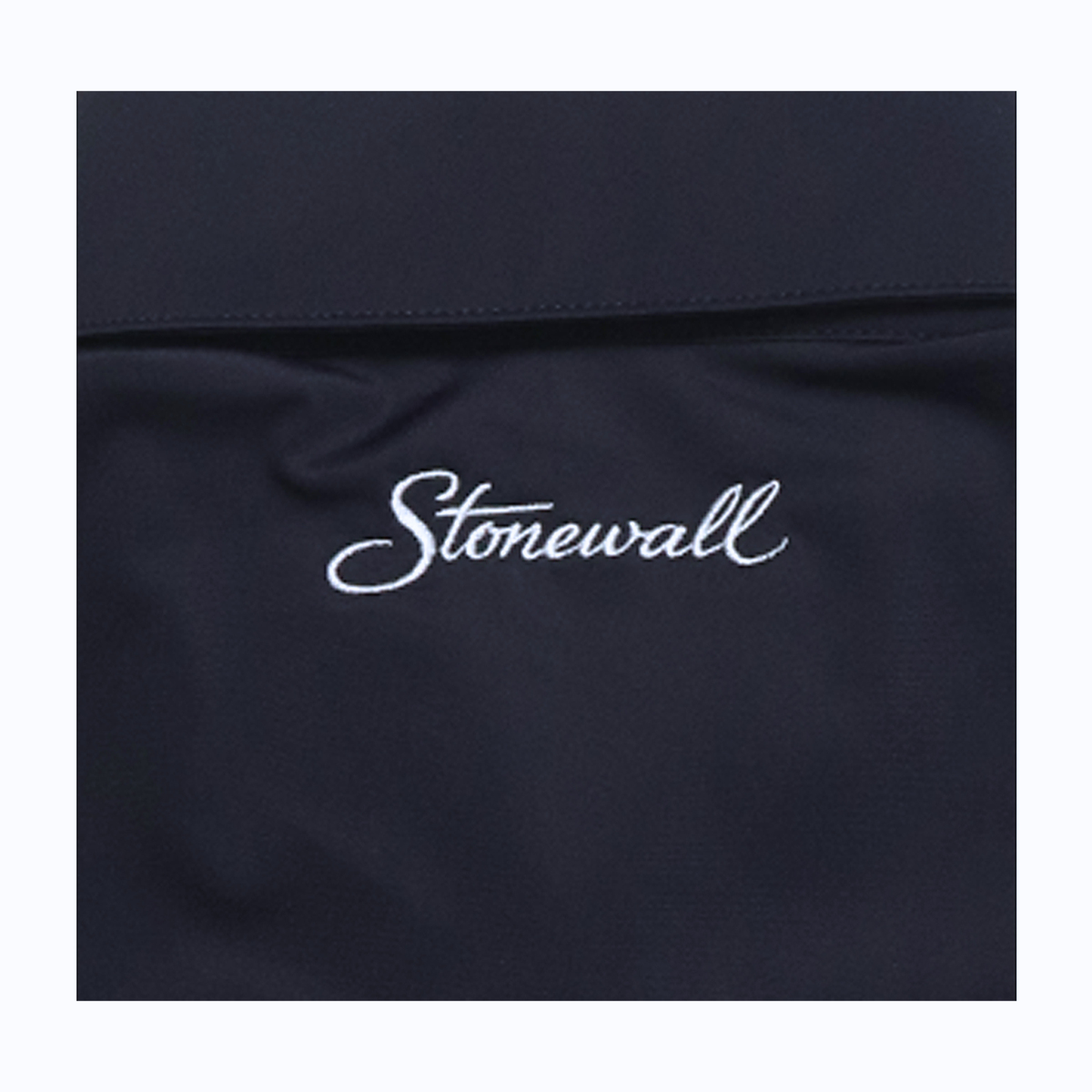 Close-up of a dark navy fabric surface with the word 'Stonewall' embroidered in white script across the center.