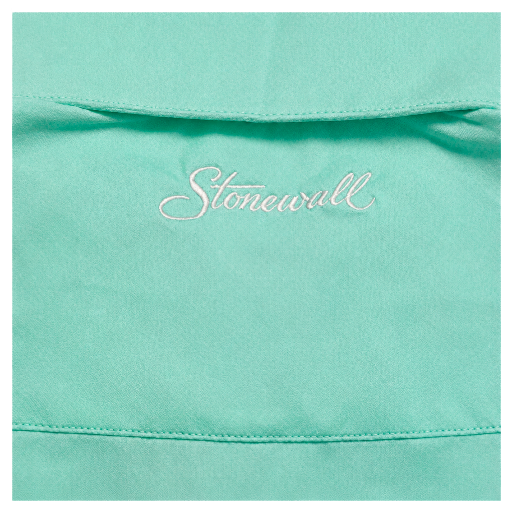 A close-up of a sea foam green fabric surface with a small white embroidered script reading 'Stonewall' centered on the chest area.